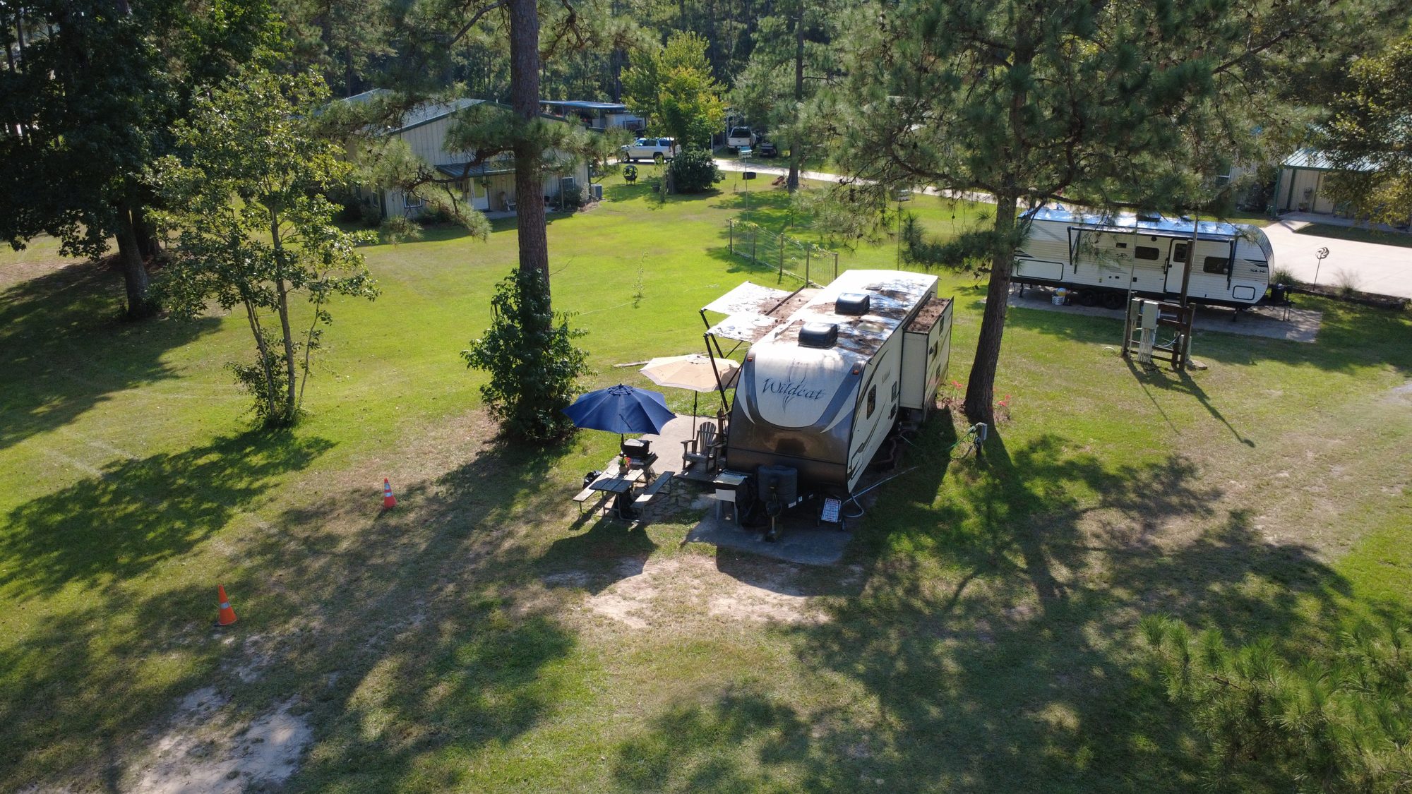 RV site under large shade trees with open lawn